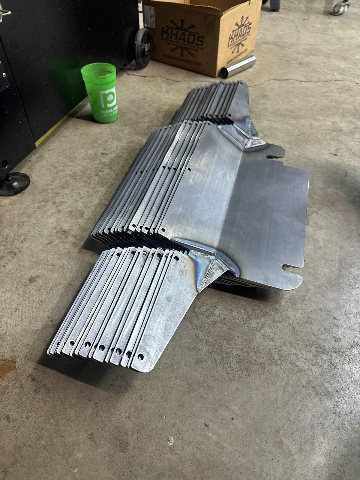 Stack of welded sheet metal brackets on the shop floor