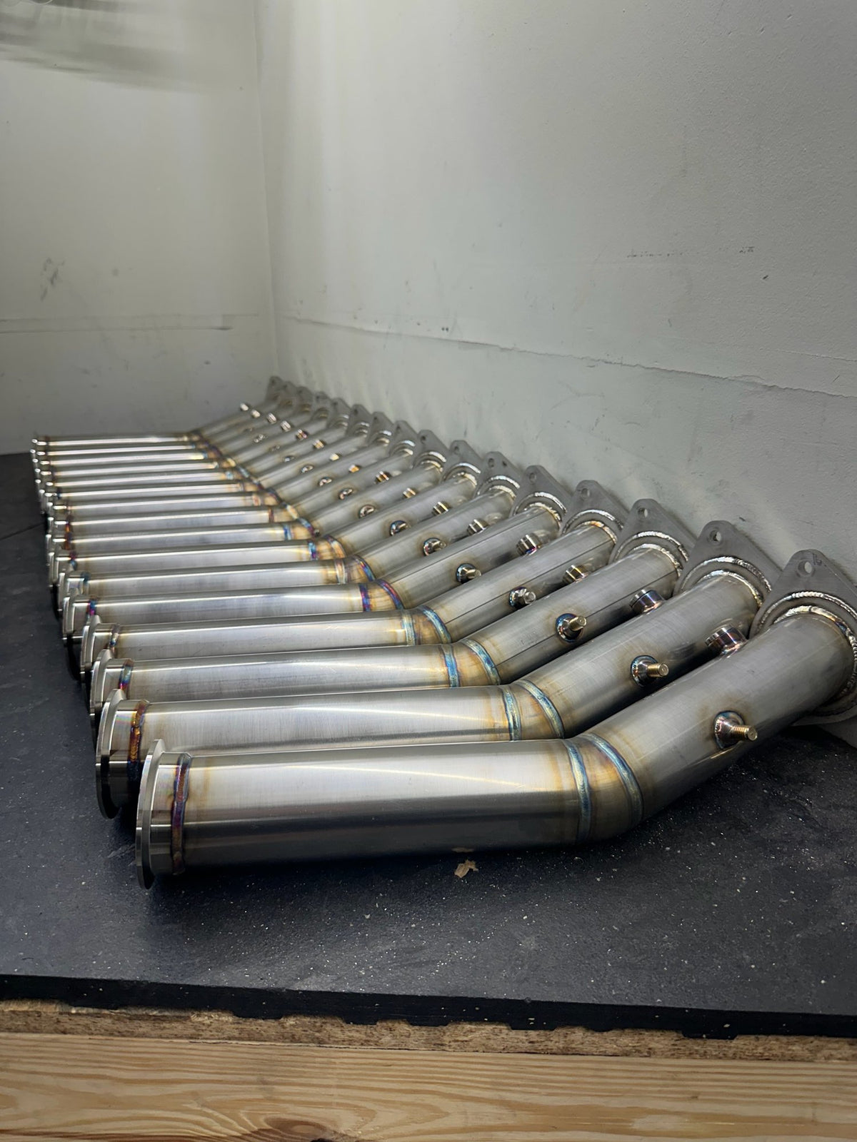 Production batch of welded parts lined up in the Tomlin Performance shop